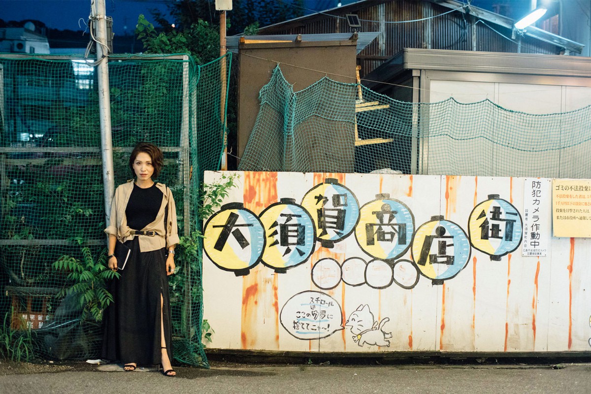 大須賀商店街の看板の前に立つ大須賀研究員