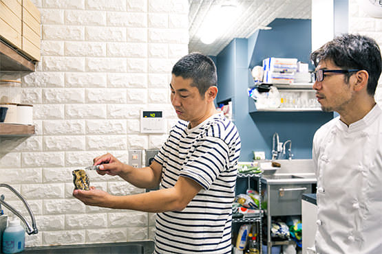 広島から持ってきた牡蠣の殻を開ける鈴木研究員