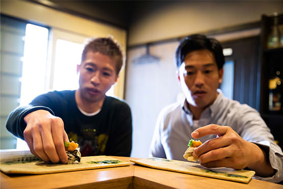 初めての春牡蠣握りを手に取る森﨑浩司さんと､天谷宗一郎さん